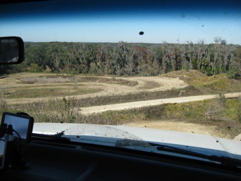 1994 Ford Bronco - View from inside a vehicle overlooking an off-road track and wooded area. Supermotors.net logo is visible.
