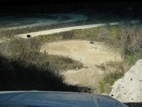 1994 Ford Bronco - A dirt track winds through a dry, grassy landscape, viewed from the perspective of a vehicle.