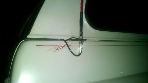 1979 Ford Bronco - Side view of a white vehicle red pinstripes and an antenna.