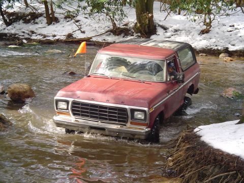 1993 Ford Bronco - This red 1978 Ford Bronco navigates a shallow stream with snow on the banks.