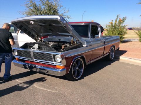 1979 Ford Bronco - This two-tone pickup truck features custom wheels and its hood is open, revealing the engine bay.