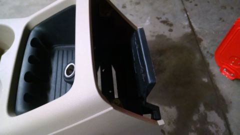 1994 Ford Bronco - Close-up of a vehicle's center console storage area and cup holder.