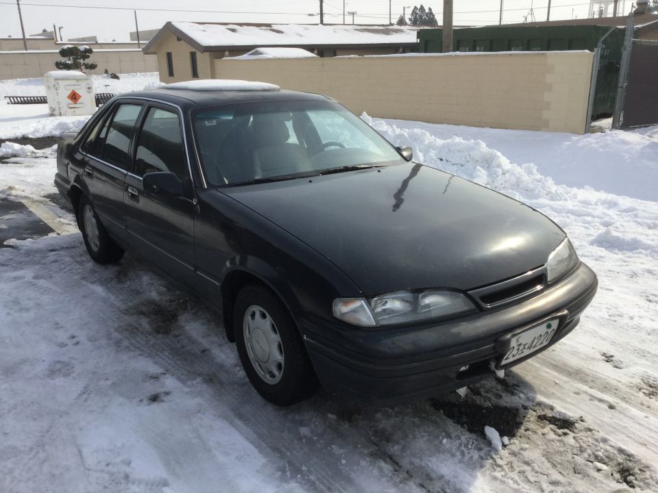 1995 Holden Astra sedan parked on snowy ground, front quarter view