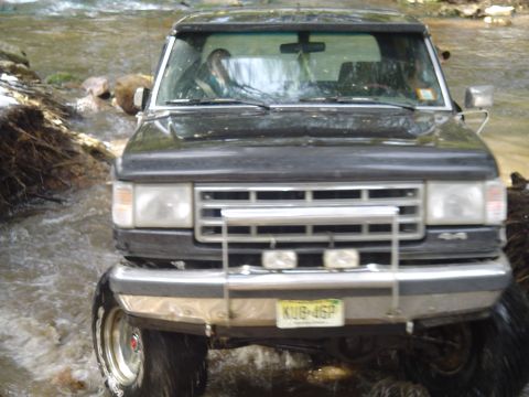 1993 Ford Bronco - This Ford Bronco is navigating a rocky stream bed with water flowing around it.