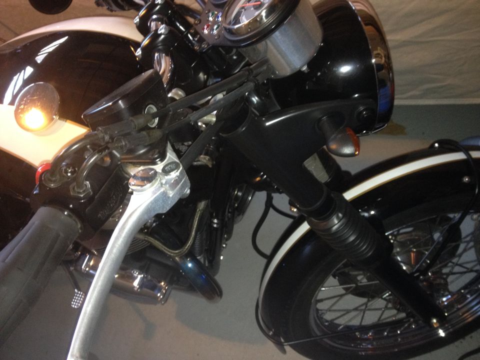 motorcycle handlebars, brake lever, turn signal, and front wheel with spokes