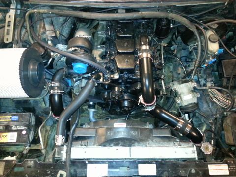 1994 Ford Bronco - The engine bay is filled with a large diesel engine, complete with a turbocharger and air intake system.