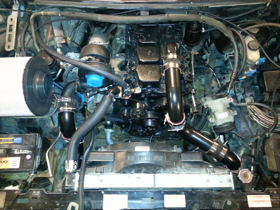 engine bay showing a large diesel engine with turbocharger, air filter, and radiator