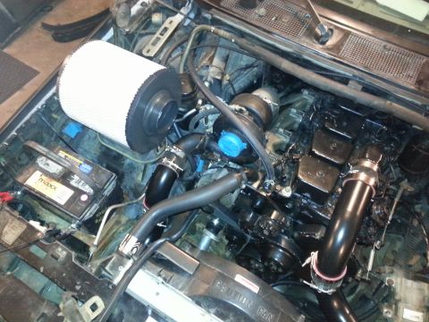 1994 Ford Bronco - Close-up view of an engine bay, showing a turbocharger, air intake system, and battery.