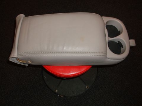 1999 Mercury Grand Marquis - Center console part with cup holders and armrest, likely from a car interior.