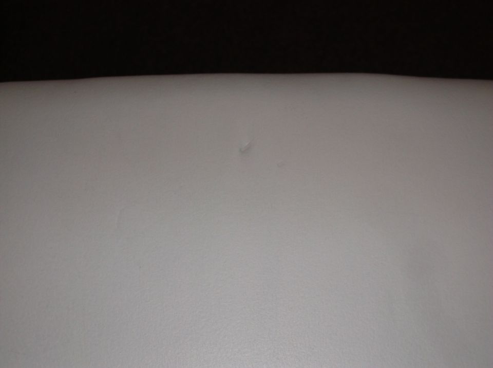 Close-up of a light-colored car seat with a small imperfection