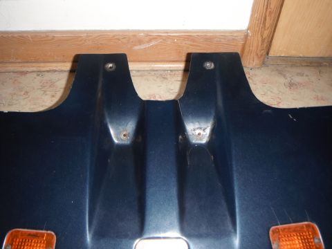 1990 Ford Bronco - This is a close-up of a dark blue plastic vehicle part with two amber lights and visible mounting points.