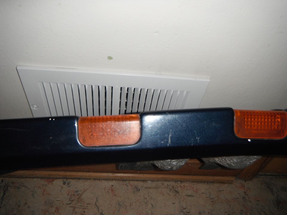 Dark blue 1990 Ford Bronco bumper with orange marker lights, showing minor scratches