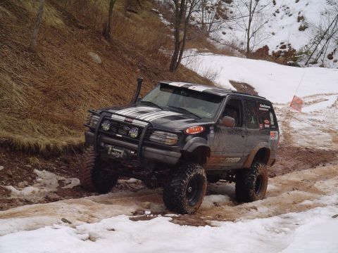 1993 Ford Bronco - This lifted 4x4 navigates a challenging off-road course with snow and mud.