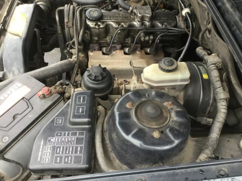 1995 Holden Astra - Close-up view of a car's engine bay, showing various mechanical parts and the battery.