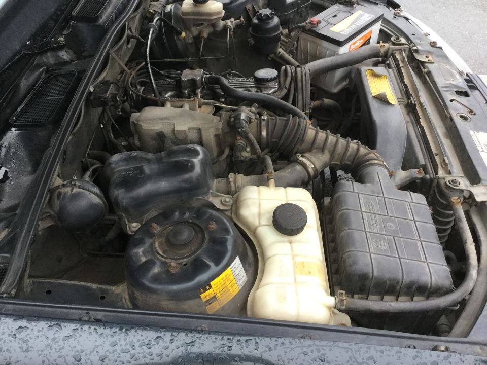 Engine bay with battery, coolant reservoir, and air intake system