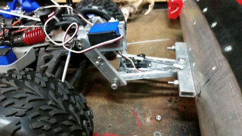 1994 Ford Bronco - Close-up view of an RC car's front suspension and steering mechanism, with a custom attachment.
