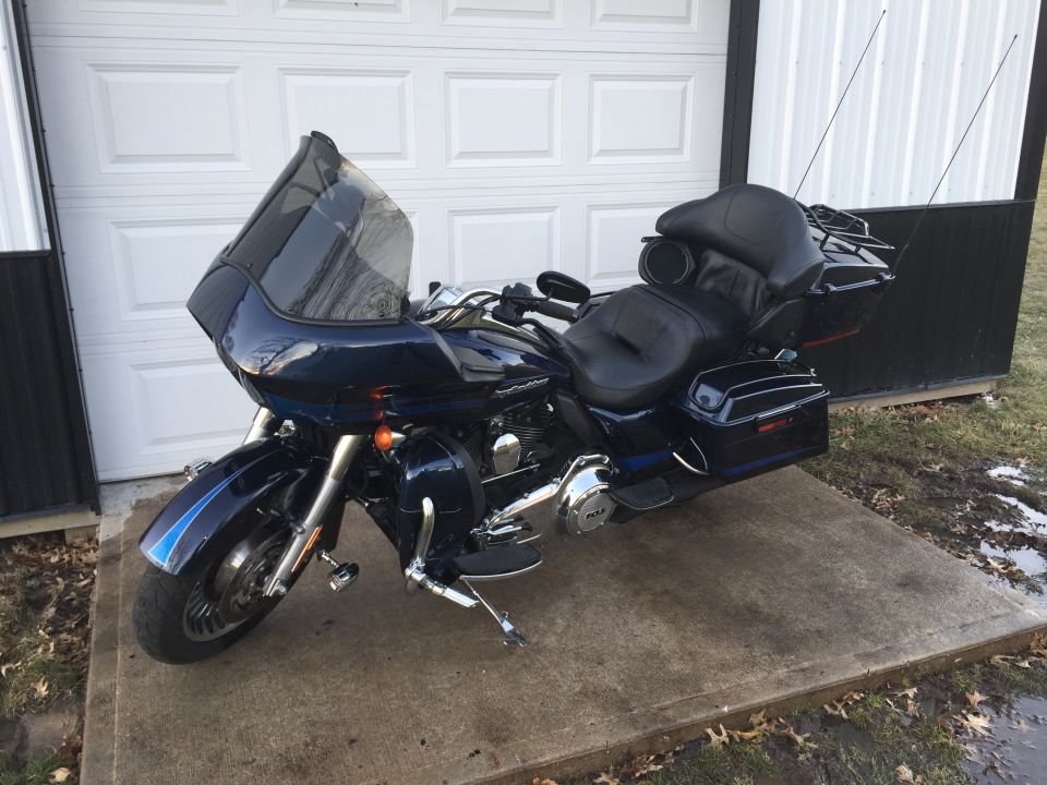 Dark blue 2013 Harley-Davidson FLHX parked in front of a garage door