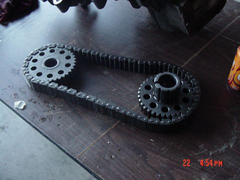 1987 Ford Bronco - A timing chain and gears are laid out on a table, with a Supermotors watermark in the corner.