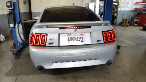 2002 Ford Mustang - Rear view of a silver Ford Mustang GT with custom LED tail lights, parked in a garage.