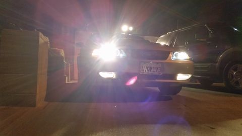 2002 Ford Mustang - The 2002 Ford Mustang's new headlights are illuminated, casting a bright glow on the front of the car.