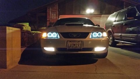 2002 Ford Mustang - A 2002 Ford Mustang is parked in a driveway at night, its updated headlights and hood scoop.
