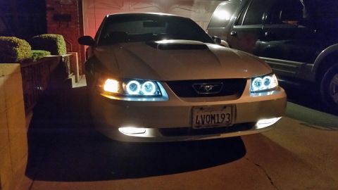 2002 Ford Mustang - This 2002 Ford Mustang features custom halo headlights and a modified grille, seen parked in a driveway at night.
