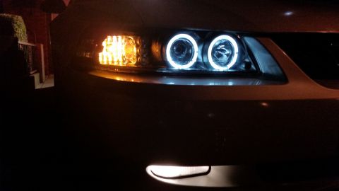 2002 Ford Mustang - Aftermarket halo headlights and amber turn signals are installed on the front of a car.