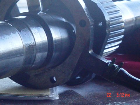 1987 Ford Bronco - A close-up view of a mechanical part, possibly a crankshaft, with a gear attached. The image includes a timestamp and website watermark.