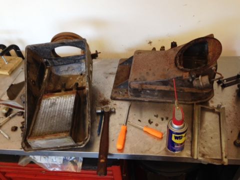 1968 Mercury Cougar - Disassembled heater core and blower assembly components sit on a workbench alongside tools and a can of WD-40.