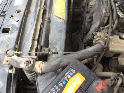 1995 Holden Astra - Close-up view of a vehicle's engine bay, showing various components and a caution sticker.
