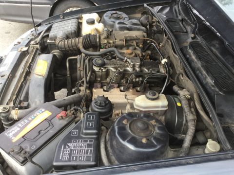 1995 Holden Astra - The engine bay of a vehicle, showing the battery, fuse box, and engine components.