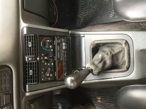 1995 Holden Astra - Close-up of a car's interior, focusing on the gear shifter and the center console with radio and climate controls.