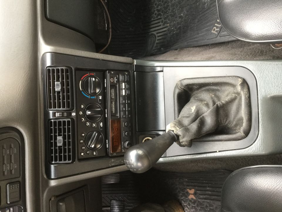 Interior view of a manual gear shifter and radio console