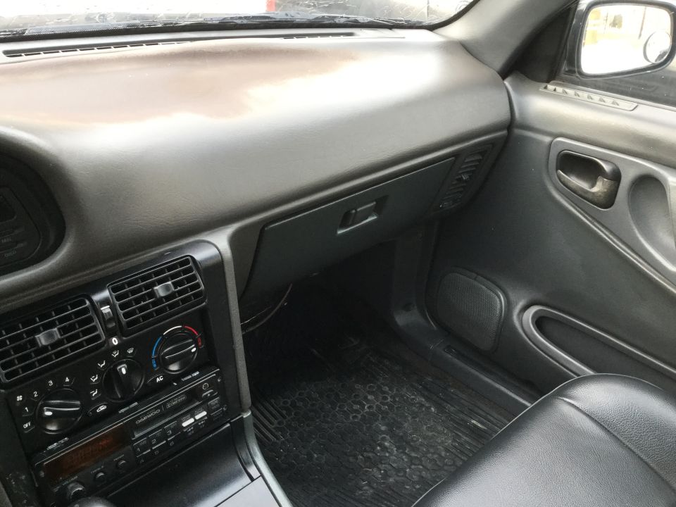Car interior showing dashboard, air vents, radio, and door panel