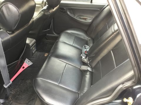 1995 Holden Astra - Interior view of a car's back seat, showing the leather upholstery and floor mats.