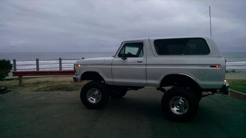 1979 Ford Bronco - A lifted 1978 Ford Bronco is parked near the ocean on an overcast day.