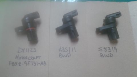 1996 Ford Bronco - Three different vehicle speed sensors are laid out on a surface with their part numbers written below.