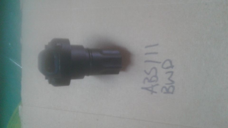 Black ABS sensor with handwritten text 'ABS/111 BWD' on a light-colored surface