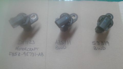 1996 Ford Bronco - Three automotive sensors are laid out with part numbers and brand names written next to them.