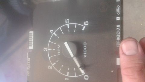 1996 Ford Bronco - A close-up of a vehicle's tachometer gauge, showing RPM markings and part numbers.
