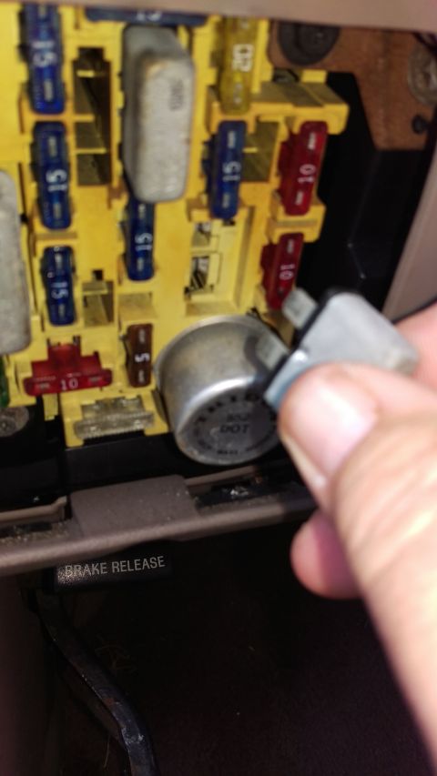1994 Ford Bronco - Close-up of a vehicle's fuse box with a hand removing a relay.