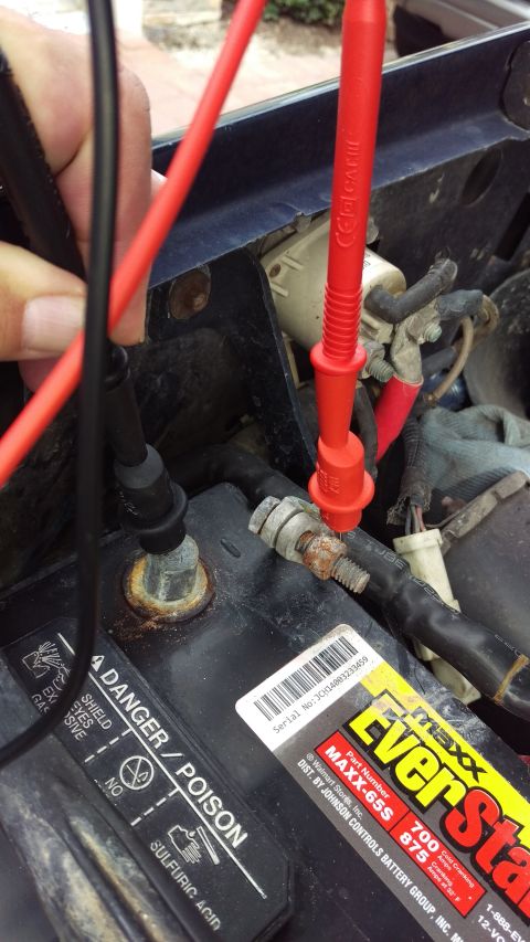 1994 Ford Bronco - Testing a car battery with a multimeter to diagnose a parasitic drain issue.