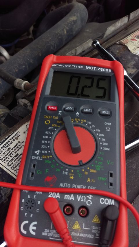 1994 Ford Bronco - An automotive multimeter is used to measure parasitic drain in an engine bay.