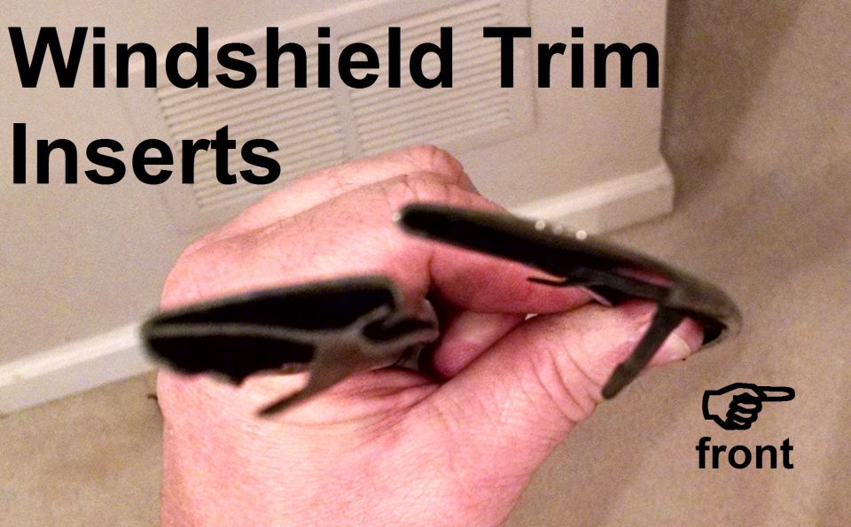 Hand holding black windshield trim insert strips with 'front' label