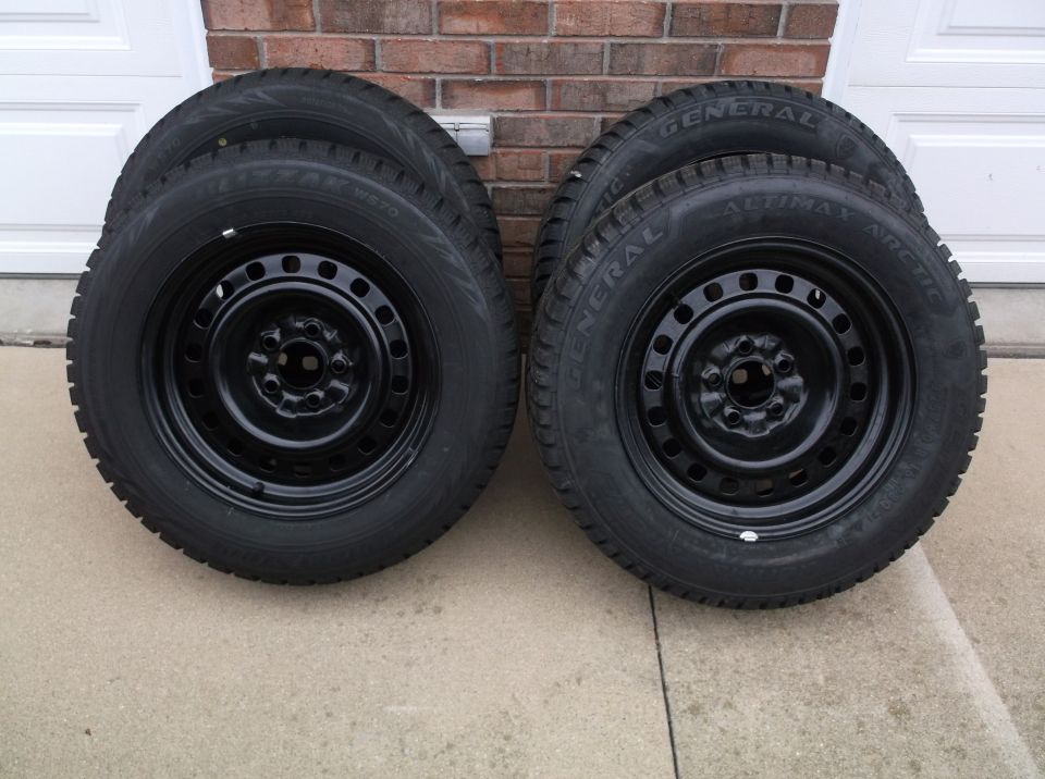 Four black steel wheels with General Altimax Arctic tires stacked in pairs
