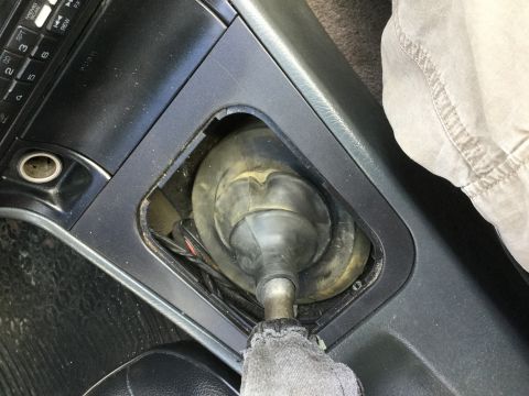 1995 Holden Astra - Close-up of the gear shifter boot and linkage in a vehicle's interior.