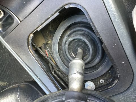 1995 Holden Astra - The interior of a vehicle shows the gear shifter boot and surrounding console, with visible wiring beneath.