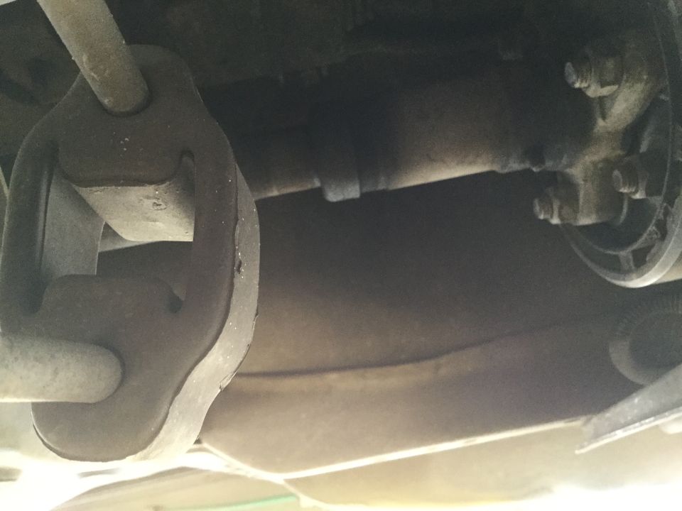 Exhaust hanger and pipe assembly on underside of vehicle