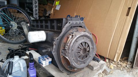 1981 Ford Bronco - Engine block and clutch assembly are visible, along with a bicycle wheel and various other items.