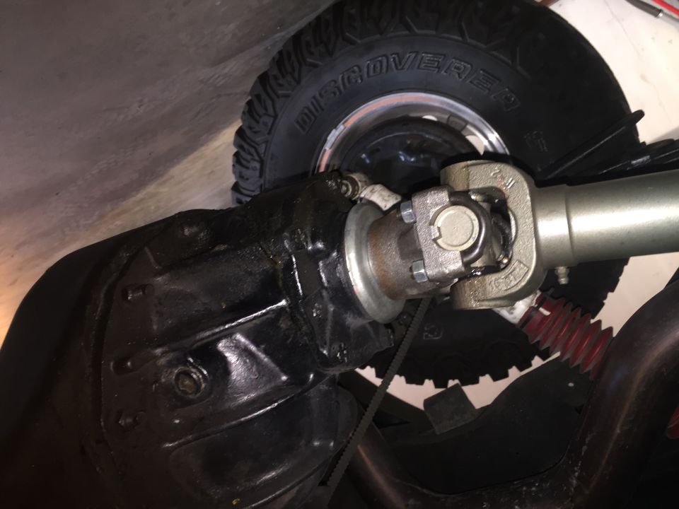 Close-up of a vehicle's driveshaft, U-joint, differential, and tire